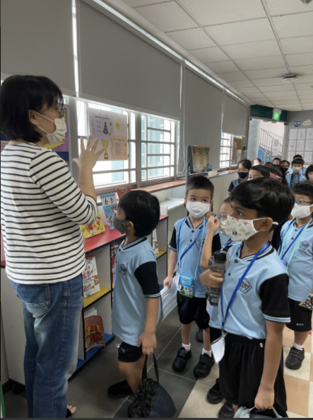 The librarian giving a tour of the school library to the Primary 1 pupils